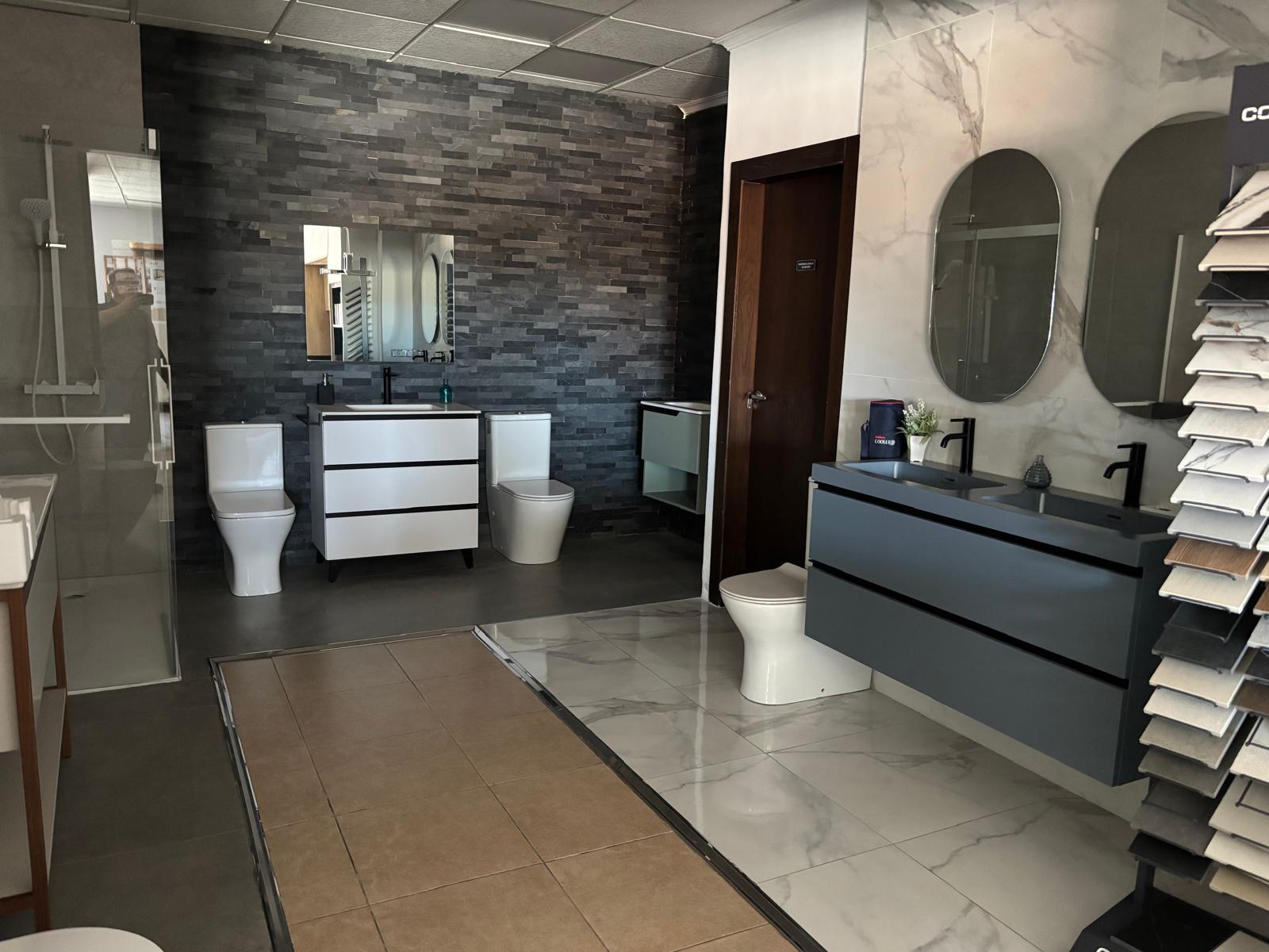 Baño de exposición con pared de piedra oscura y ducha con mampara