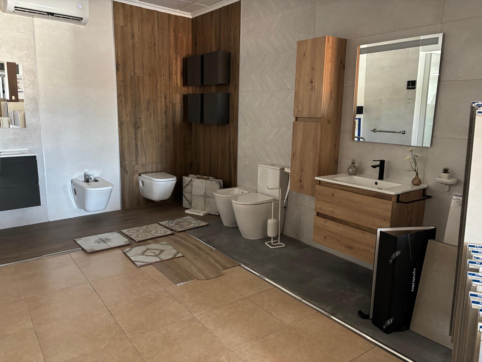 Exposición de baños con doble lavabo en mármol y espejos ovalados